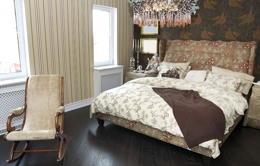 Quilted headboard, patterned wallpaper and chandelier