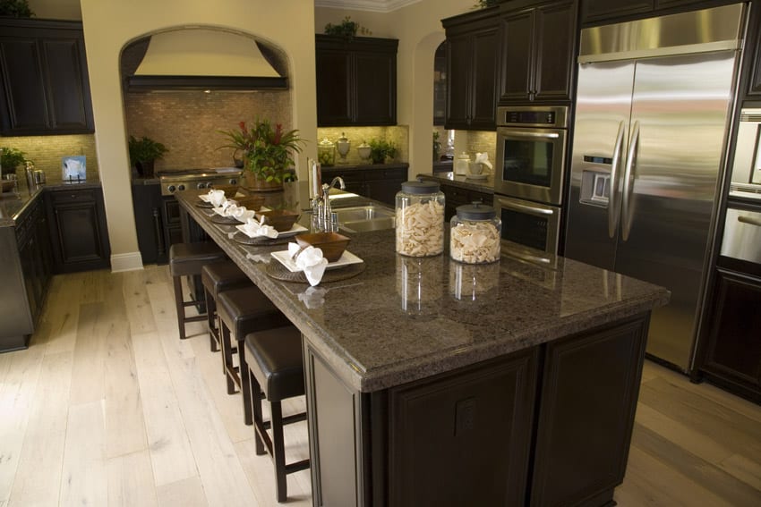 Dark wood cabinet kitchen with dark granite light flooring and tile backsplash