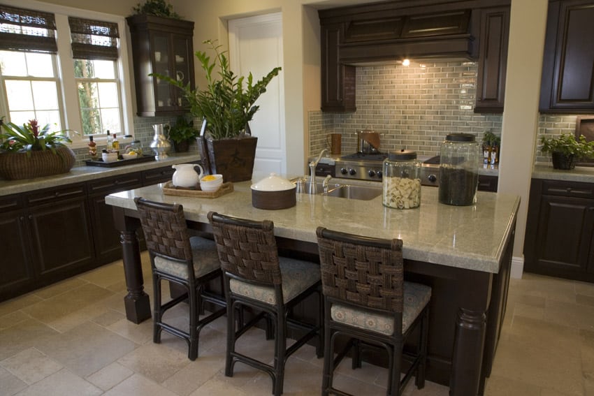 Dark wood cabinet kitchen with light granite counter and rattan bar stools