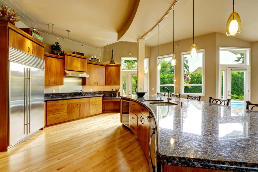 Designer kitchen with granite counters, wood flooring and curved island