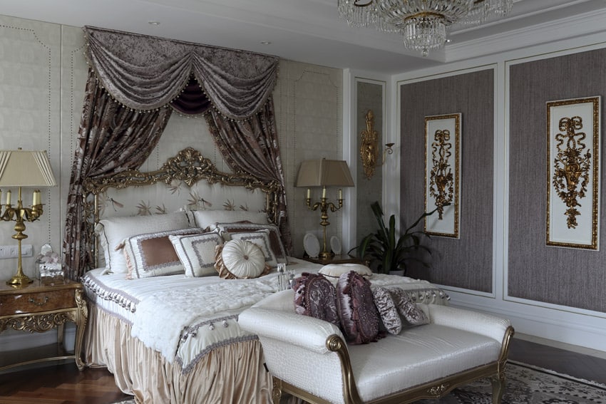 Luxurious bed with gilded frame, crystal chandeliers and lilac wallpaper