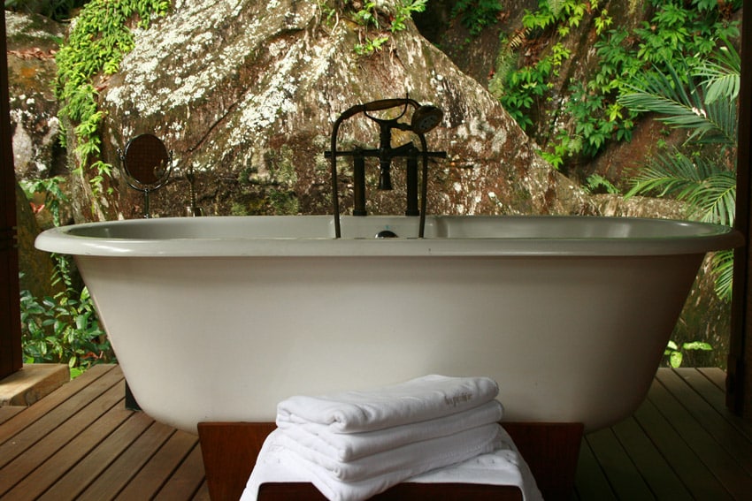 Gorgeous outside bathtub next to rock wall