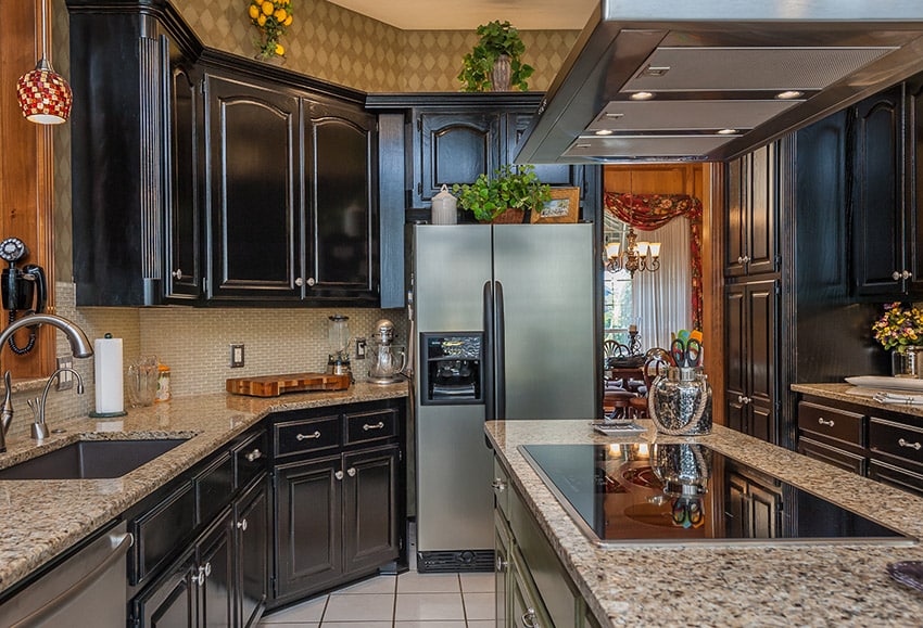 Kitchen with dark wood cabinetry beige granite counters