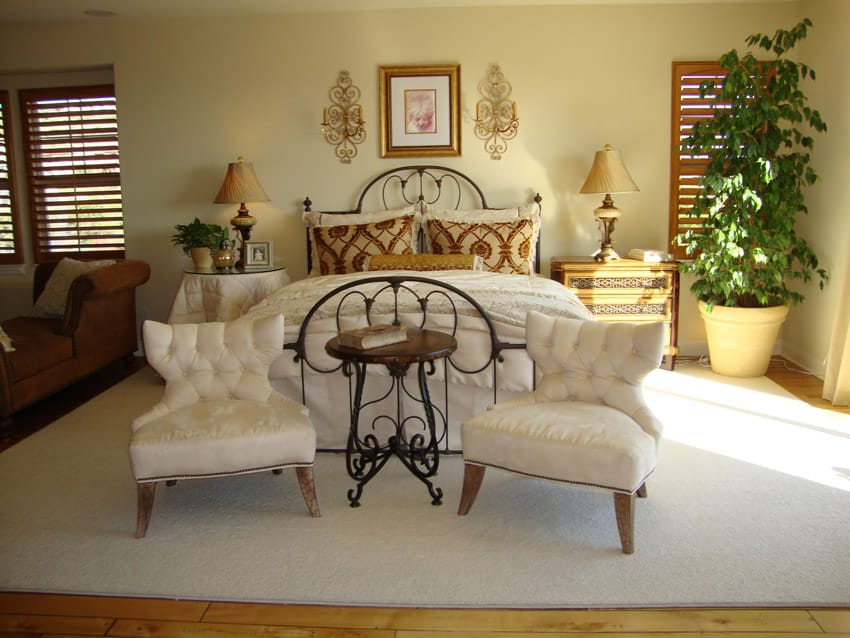 Wrought iron bed, white fabric chairs and off white rug