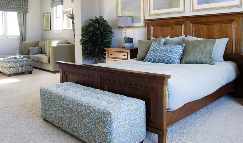 Light blue bedding, olive pillows, art and bedisde table
