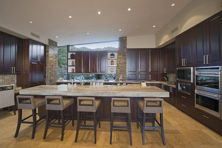 Long rectangular dining island with thick slab granite in kitchen