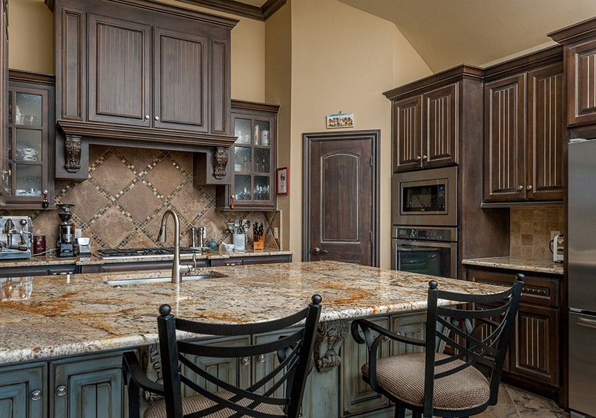 Kitchen with cream walls with and backsplash made of brown ceramic and mosaic tiles