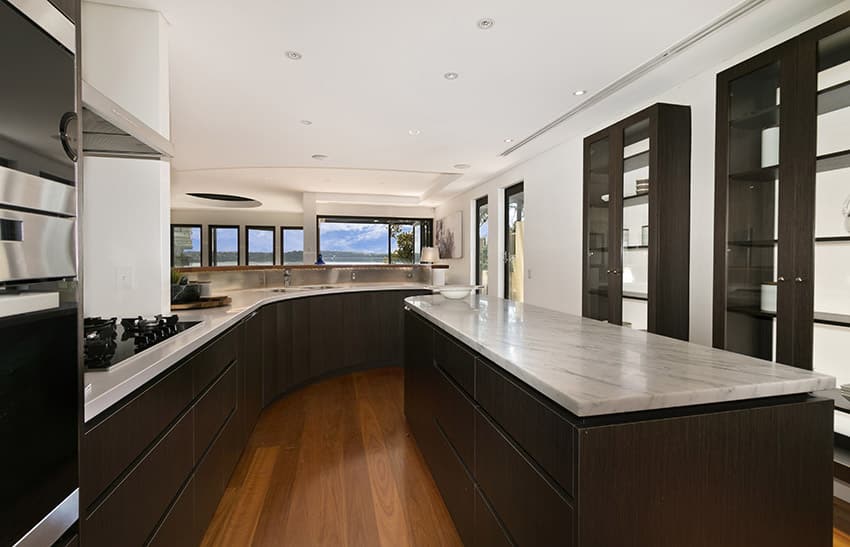 Upscale modern dark wood kitchen with white counters