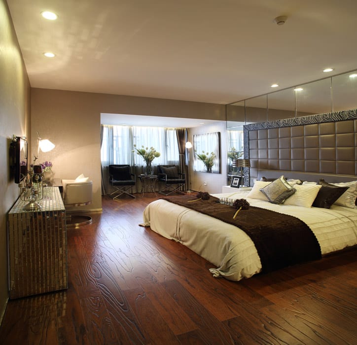 Mirror panels on walls and console table adjacent to an eggwhite bed