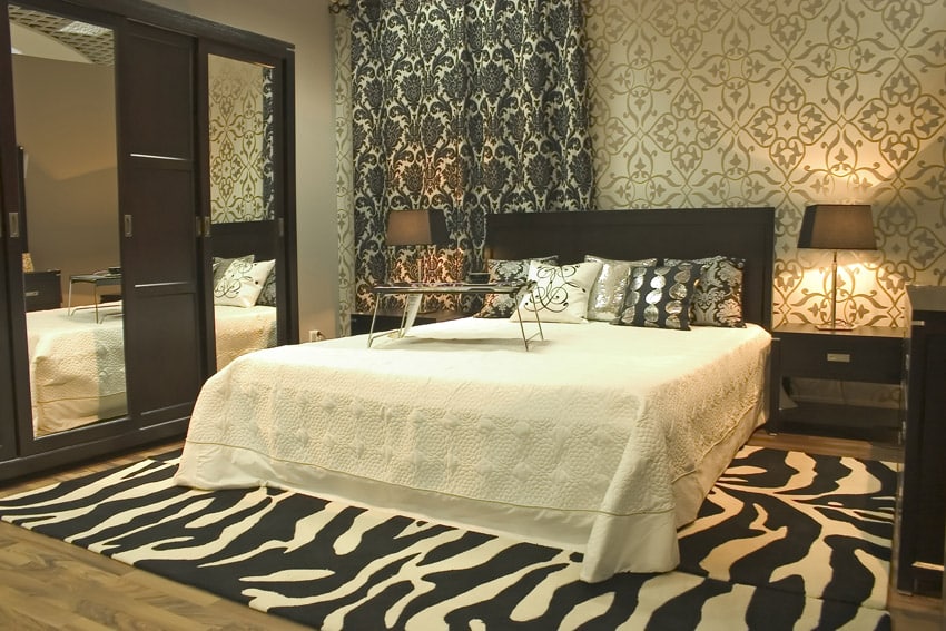 Master bedroom with patterned wallpaper and zebra area rug