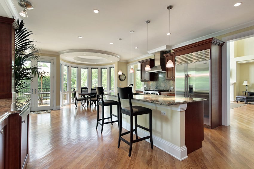 Beautiful open layout kitchen with rectangular dining island and pendant lights