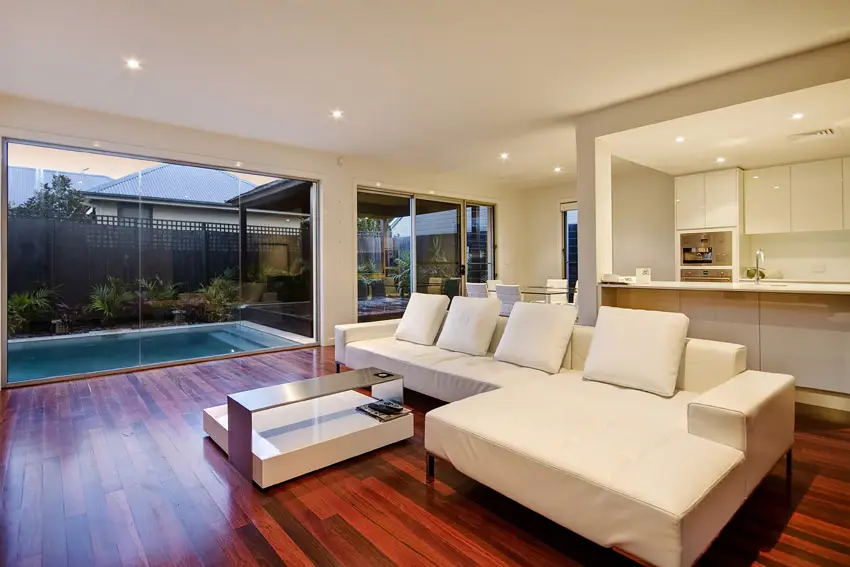 Beautiful wood flooring in living room with view of backyard pool
