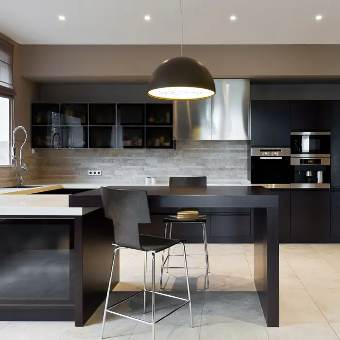 Black modern kitchen with large light fixture