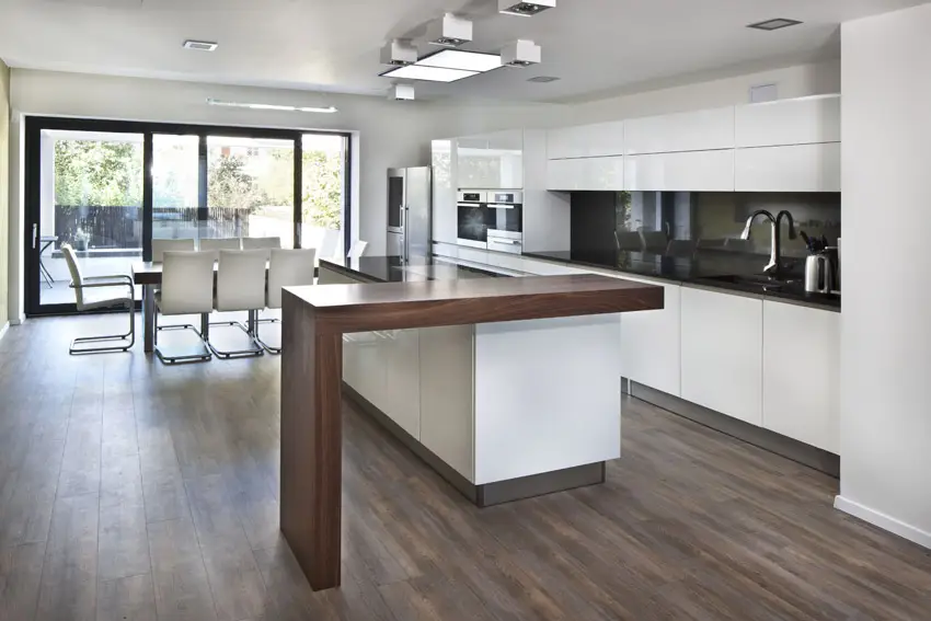 Kitchen with solid mahogany material, white Midmodern century chairs and steel kitchen accessories