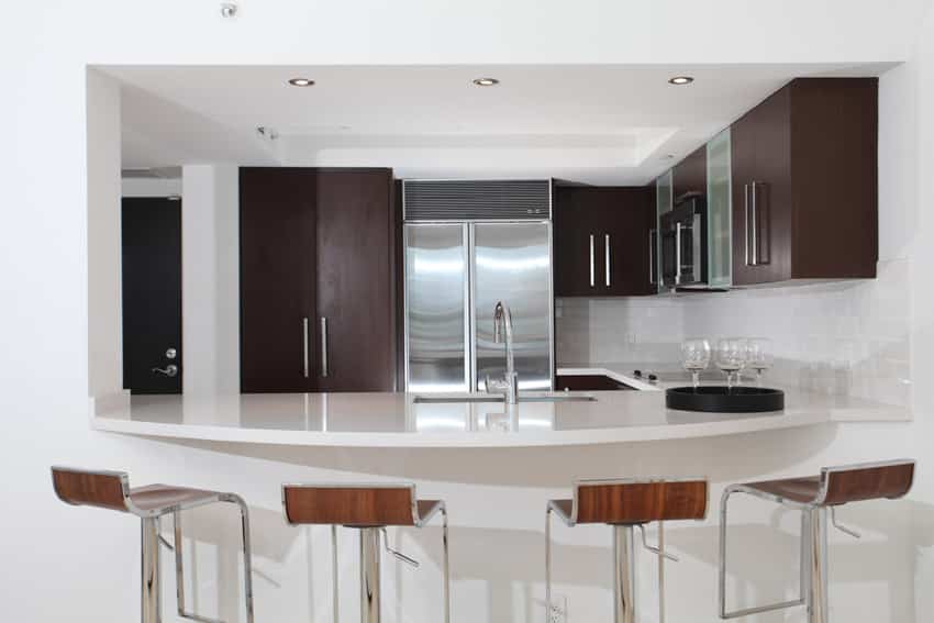 Eat in kitchen with white bar island and plywood cabinets