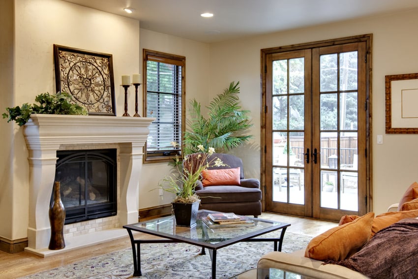 Living room with white fireplace and wood frame windows and door