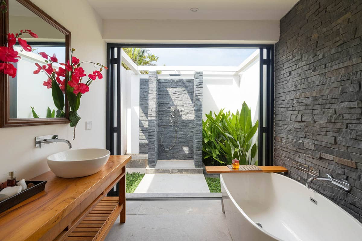 Tropical bathroom with private outdoor shower