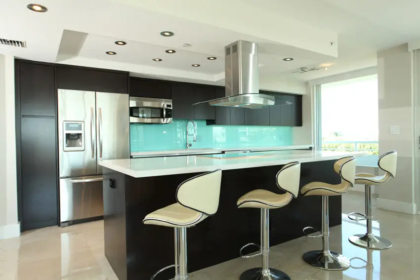Kitchen with aqua backsplash and white solid surface counter