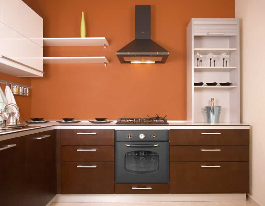 Orange kitchen with chocolate brown cabinets and aluminum pulls