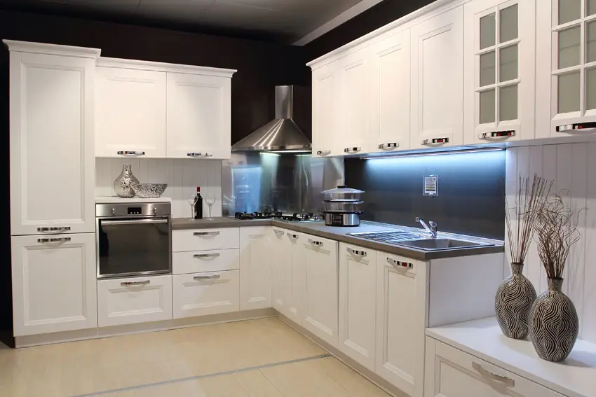 Modern corner kitchen with white cabinetry with chrome hardware