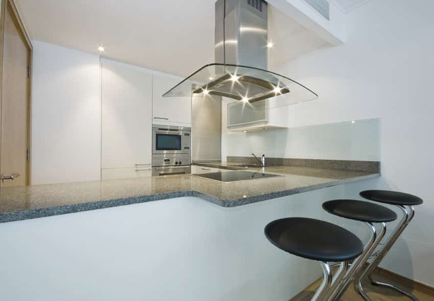Kitchen with built-in wall storage and glass oven hood