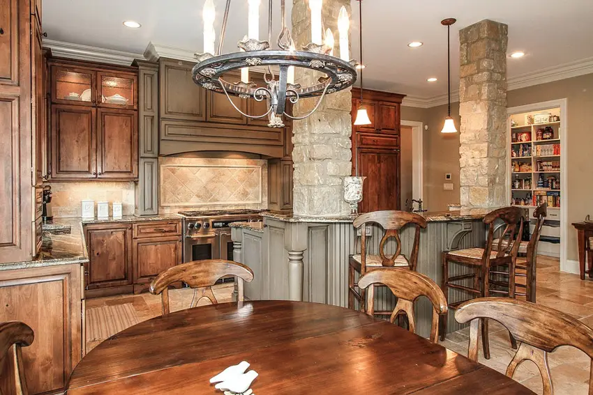 Kitchen with wagon wheel chandelier and stone clad columns