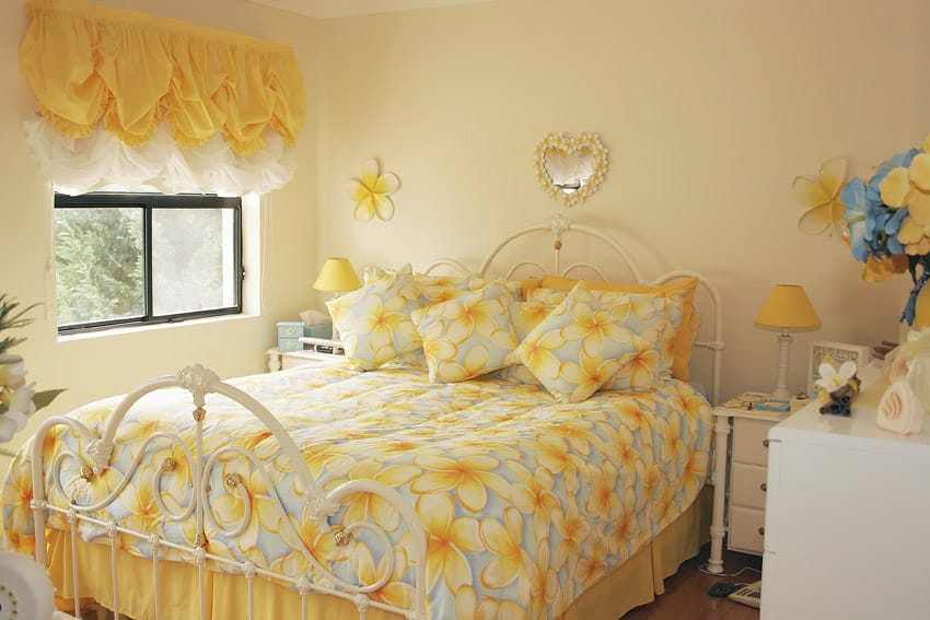 Bright yellow bedroom with decorative metal bed frame