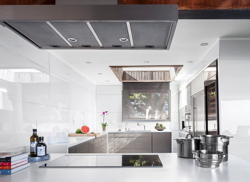 Kitchen with glossy tiles, skylights and gray undersink cabinets