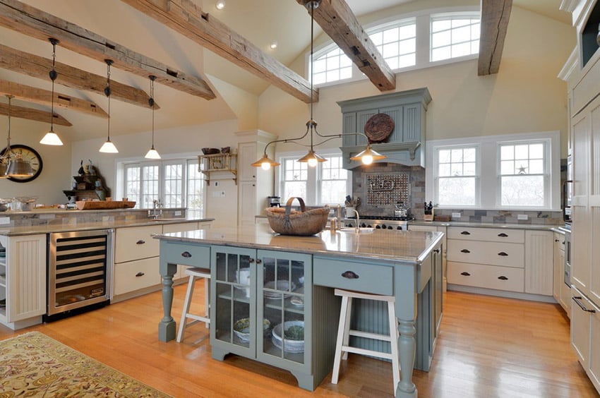 Country kitchen with large rustic island, expsoed wood beam ceiling and bright wood floor