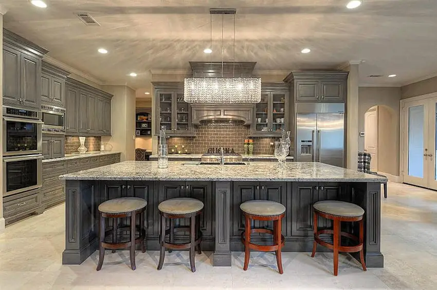 Custom wood island in luxury home with gunmetal color cabinets and chandelier