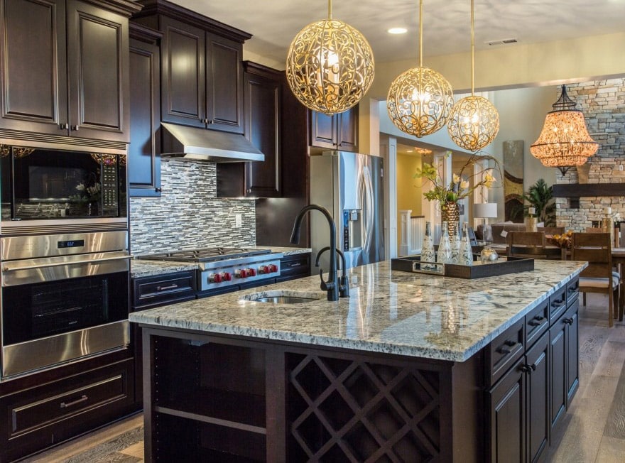 Golden globe lighting in a dark color scheme kitchen