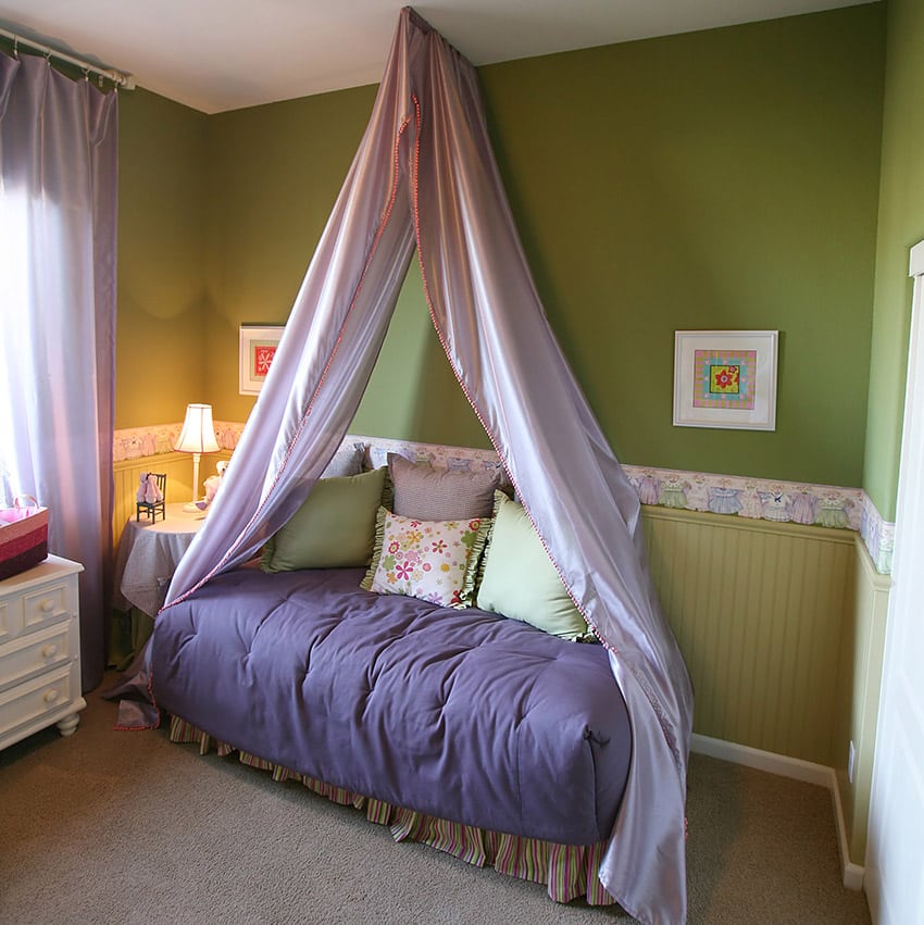 Girls bedroom with purple bed drapery