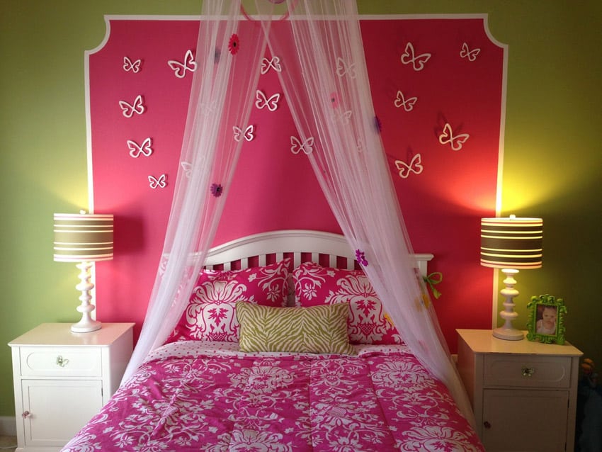 Bedroom with-sheer bed curtain and pink accent wall with butterflies