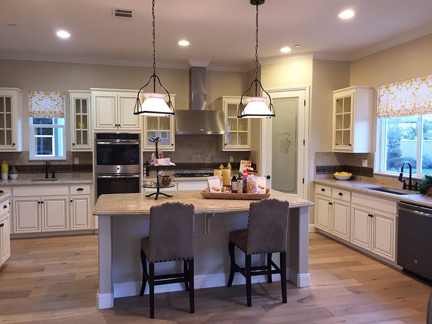 Kitchen in new model home with dining island and white cabinetry
