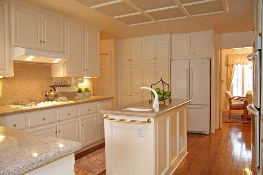 Kitchen with cream colored cabinets and sink with white faucet