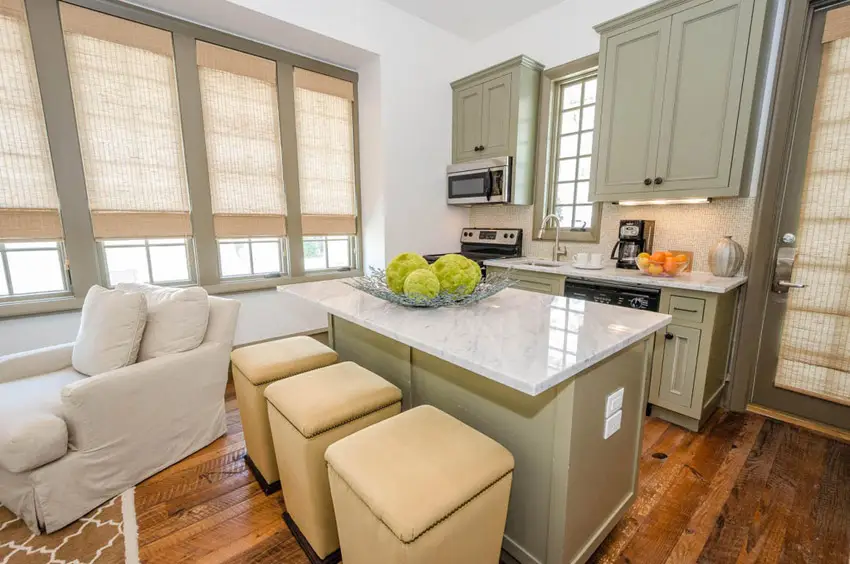 Kitchen with upholstered stools, windows with blinds and white sofa