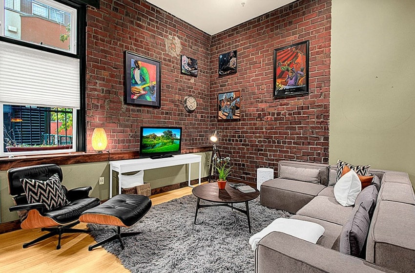 Modern living room with brick wall and light wood flooring
