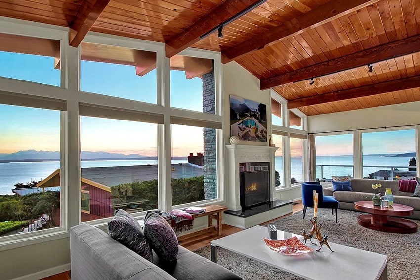 Modern living room with high arched wood ceiling and water views