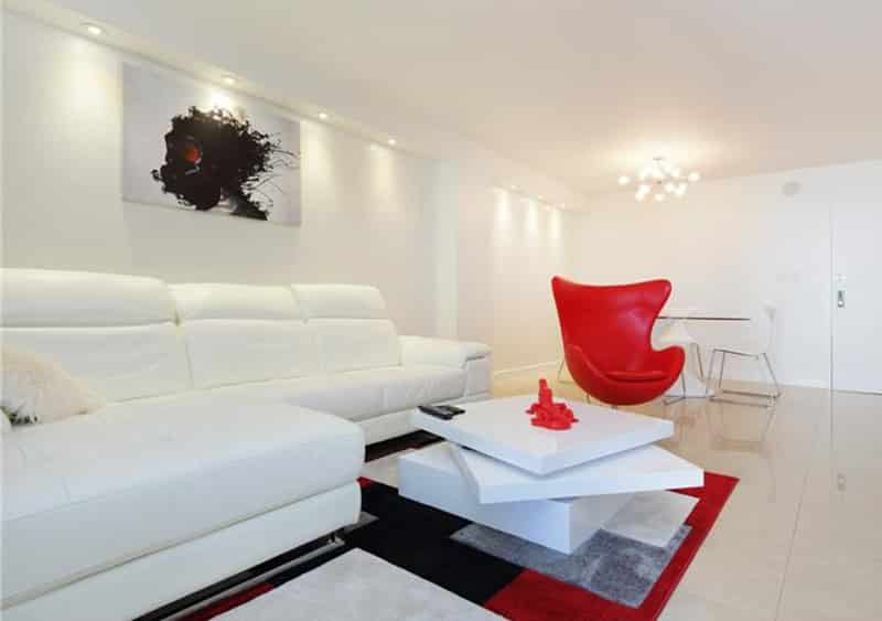 Modern living room with limestone tile flooring and bright red accent pieces