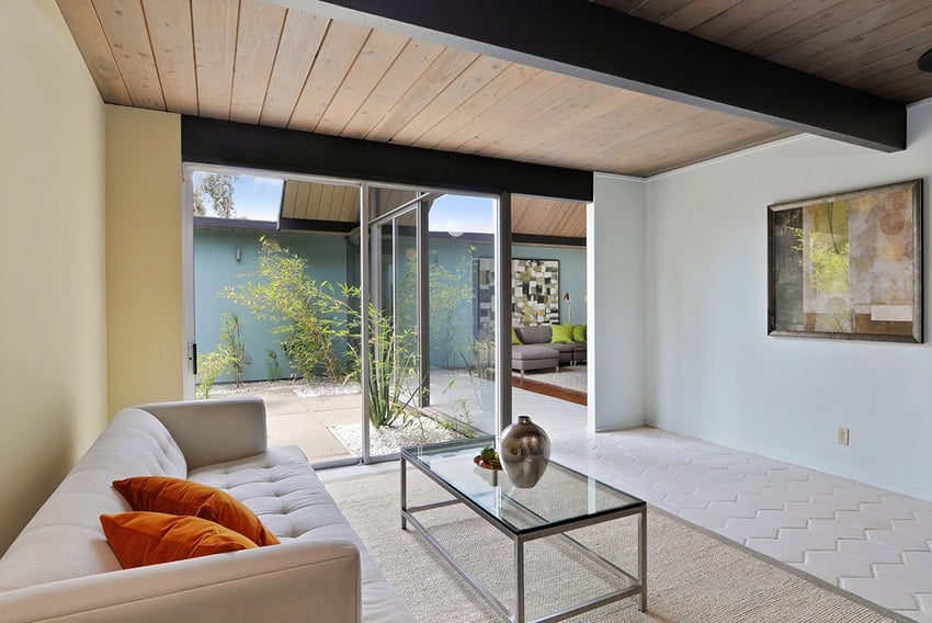 Modern living room opens to atrium with slanted wood beamed ceiling