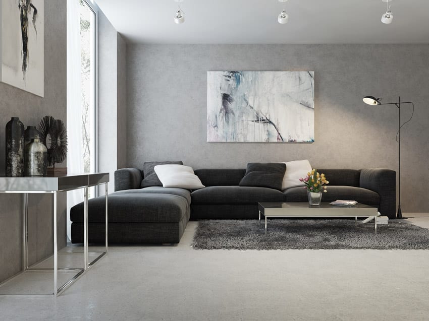 MArbled gray wall with black fabrci sofa with white accent pillows