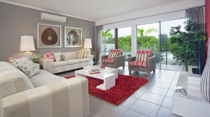 Striped sofa, rattan armchairs with red cushions and white tiles