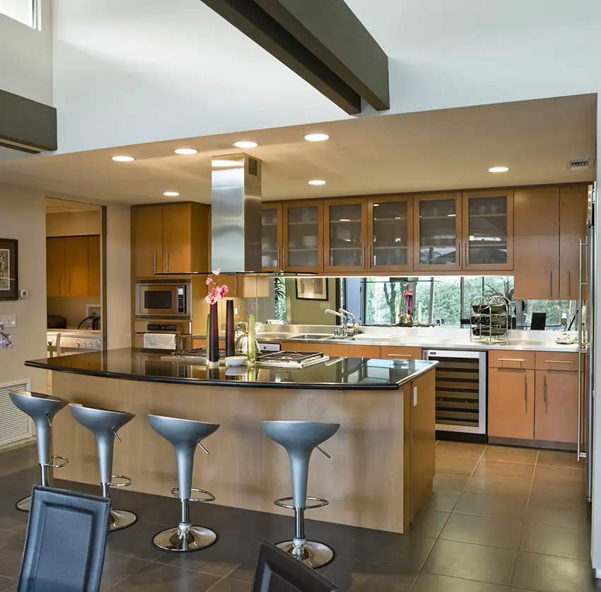 Kitchen with wood framed glass doors for the cabinets and black granite counters with exposed beams