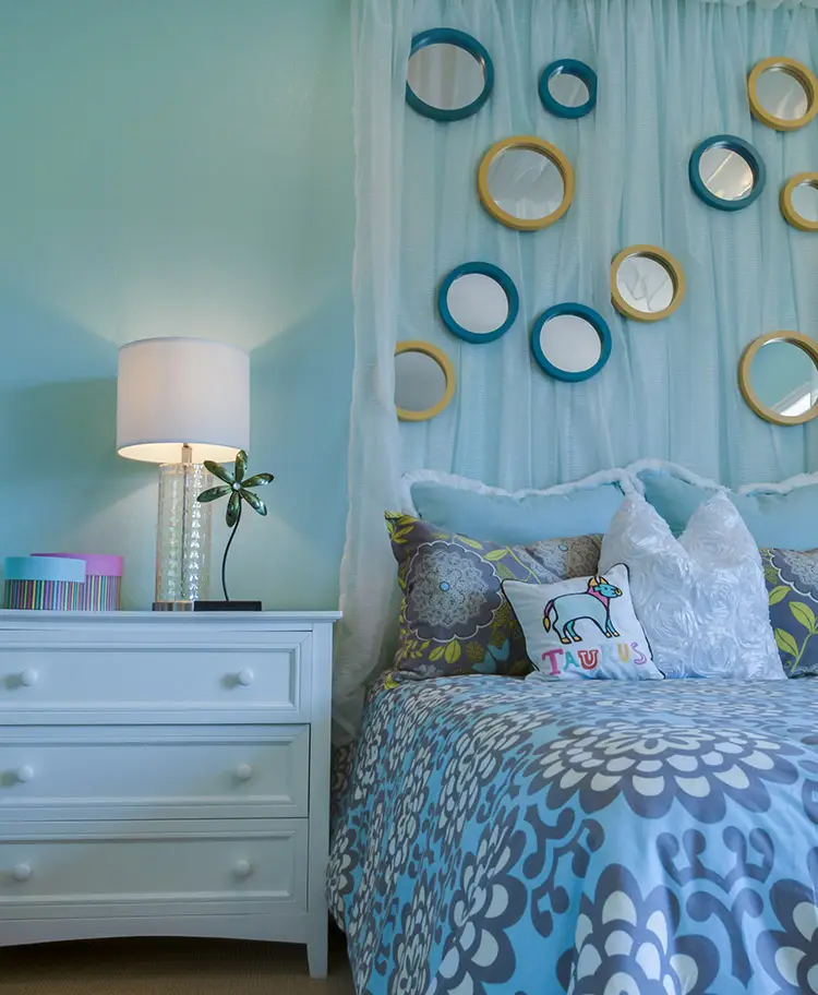 Pretty blue bedroom with circular wall mirrors