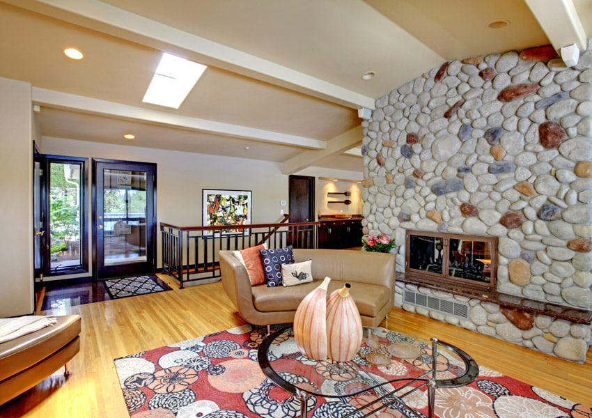 River rock fireplace with golden oak floors and indigo pllows