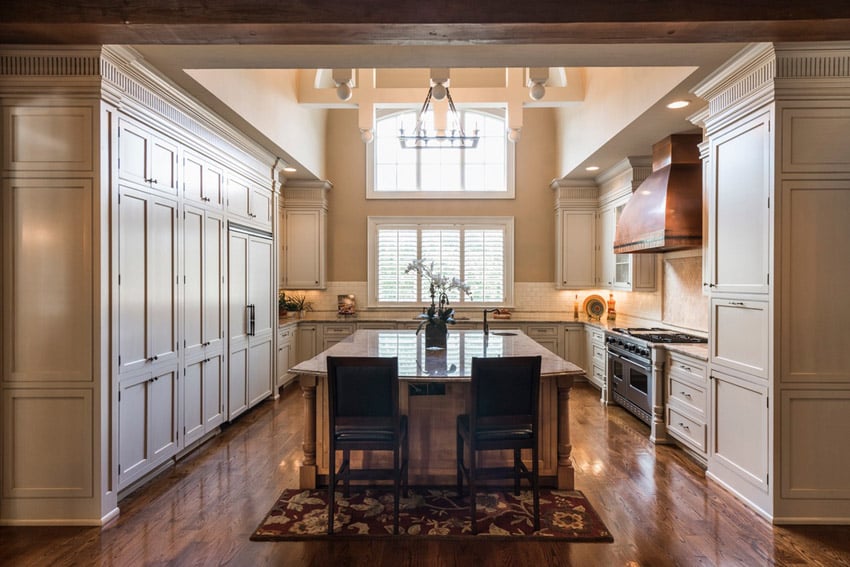 Closed kitchen with high ceilings and calcutta gold granite counters