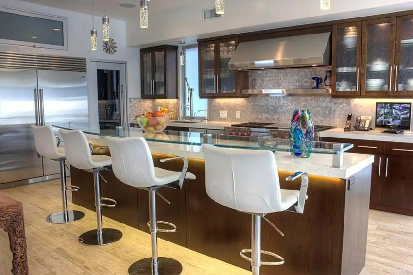 Eat in dining bar kitchen with white counters, dark cabinetry, and light wood flooring