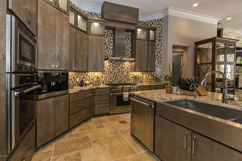 Kitchen with beige granite counters travertine tile floor and rich wood cabinets