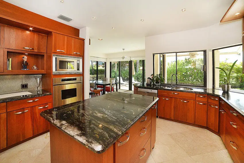Kitchen with black spice countertops, red mahogany cabinets and tropical style