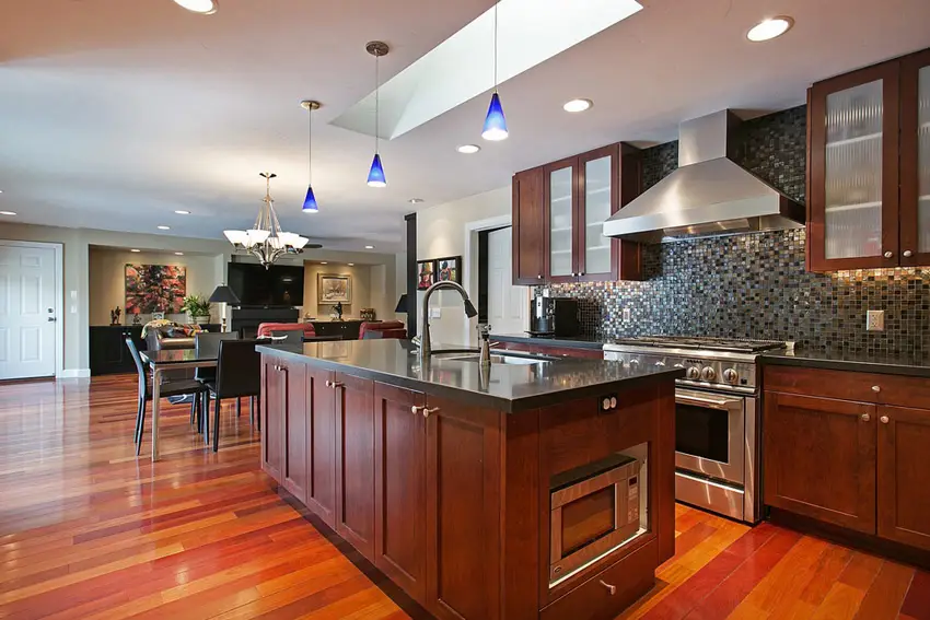 Kitchen with bright wood flooring and blue pendant lights